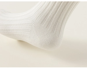 Detailed macro view of white ribbed knit cotton socks showing heel and ankle stitching