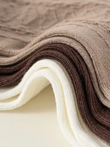 Three pairs of ribbed cotton socks for kids in cream and brown earth tones, soft knit texture