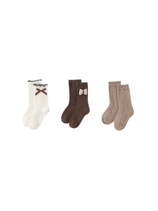 Three pairs of cotton baby socks with bows and cable knit textures in neutral tones