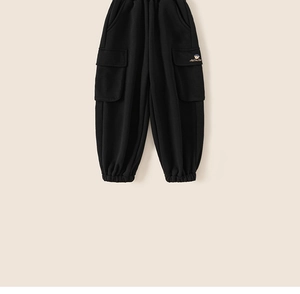 Detail of children's black jogger pants with cargo pockets and cartoon embroidery