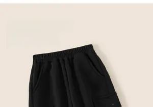 Close-up of black kids jogger pants with elastic waist and bear embroidery detail