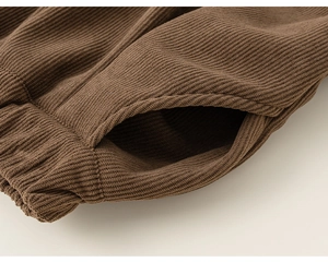 Vue détaillée de la taille élastique et de la poche latérale du pantalon en velours
