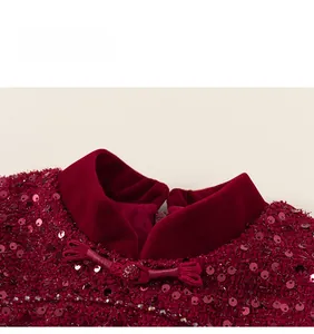 Detail of red Chinese style dress featuring traditional frog buttons and sequined fabric