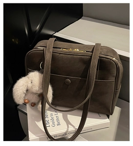 Detail view of dark coffee vintage tote bag with gold zipper and plush rabbit charm