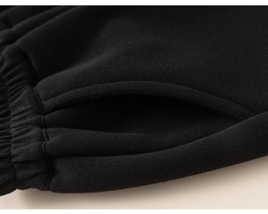 Close-up detail of smooth stitching on side pockets of black kids sport joggers