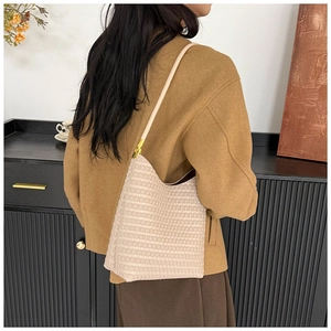 Détail du sac fourre-tout crème montrant la texture tissée et les accents dorés
