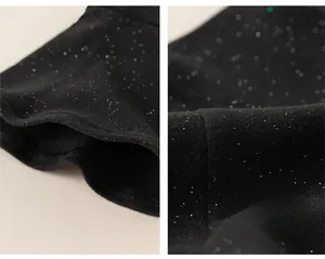 Detail of children's dress showing bell sleeves and silver glitter fabric texture