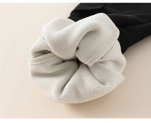 Macro detail of thick white fleece lining and black knit fabric for warm kids pants