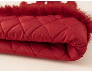 Détail du tissu matelassé rouge avec bordure en fausse fourrure pour robe de fête