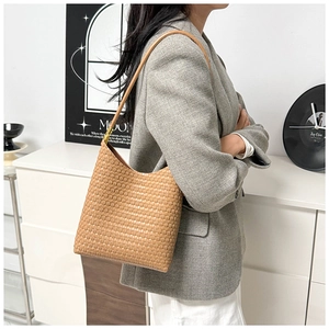 Detailed view of the woven texture and golden hardware on this light brown hobo bag