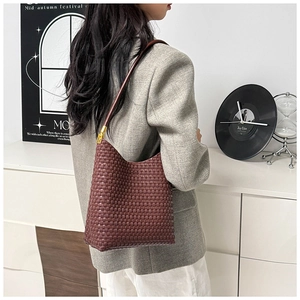 Deep red woven tote bag styled with a professional grey blazer and white trousers