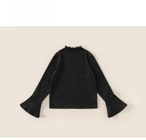 Detailed close-up of a black knit top featuring sparkling sequins and stylish bell sleeves