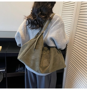 Detail of olive green suede tote bag featuring delicate daisy embroidery and alodi text