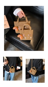 Détail des motifs de pain brodés sur un sac cabas en toile avec charme de croissant