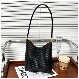 Close-up of black woven hobo bag showing texture detail and gold metal hardware