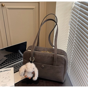 Detailed close-up of dark grey suede tote bag featuring a cute white bunny pendant and pocket