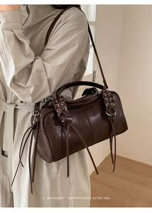 Detail of dark brown retro bowling bag with metal eyelets and long leather tassels