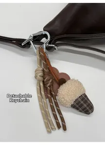 Detail of detachable bag charm with leather heart and sheepskin pendant on a tote bag