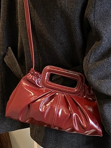 Elegant burgundy pleated patent leather crossbody bag with structured top handle