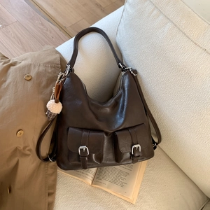 Detail of dark brown vintage tote bag with dual front pockets and plush ice cream charm