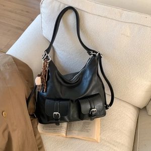 Detail of black textured leather tote with double front pockets and ice cream charm