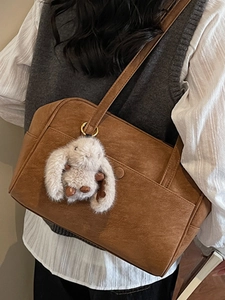 Vintage brown leather tote bag with a cute plush rabbit pendant for daily commuting fashion