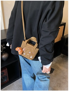 Gros plan sur un sac fourre-tout en toile marron brodé de pain avec charme chiot