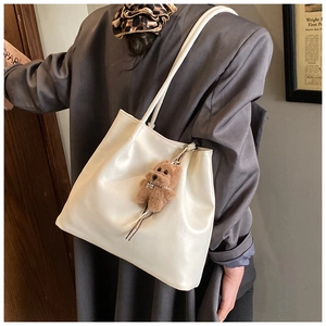 Detailansicht der weißen weichen PU-Tasche mit süßem Teddybär-Anhänger und schlichtem Design
