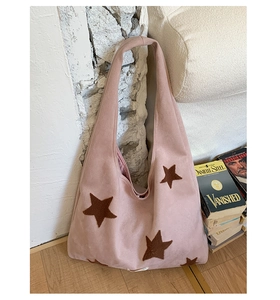Close-up of pink plush tote bag featuring brown star embroidery and soft suede-like texture