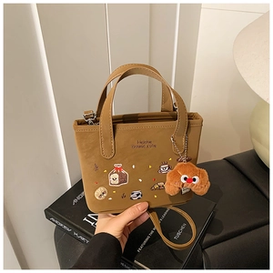 Vue détaillée d'un sac marron avec broderie gourmande et breloque en peluche mignonne