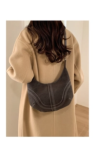 Detail of grey half-moon hobo bag showing white contrast stitching on suede texture