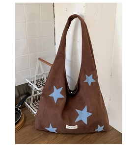 Detail of star embroidery and woven label on dark brown plush shoulder tote bag