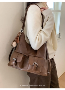 Deep brown leather hobo bag with vintage utility pockets and heart tassel charms