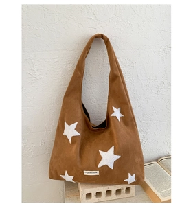 Detailed close-up of brown suede star tote bag with soft texture and white star patches