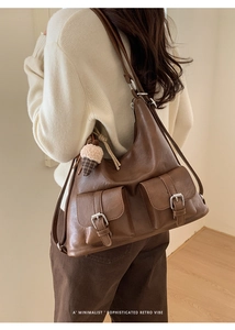 Brown retro leather hobo bag with front flap pockets shown on a model for scale