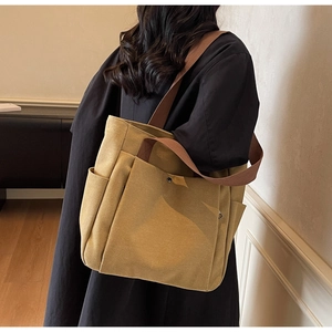 Vue détaillée du grand sac cabas en toile avec poignées renforcées et poche avant spacieuse