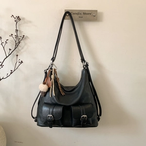Close-up of black PU leather tote bag with dual front pockets and cute hanging charms
