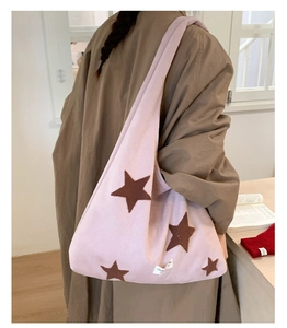 Close-up of pink star embroidery on oversized plush hobo tote bag with wide strap
