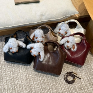 Five elegant bucket bags in classic colors with plush rabbit charms and straps
