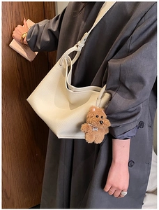 Détail du sac seau en cuir grainé blanc crème avec charmant chiot en peluche marron