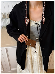 Brown suede mini crossbody bag detail with heart-patterned lanyard and silver buckle