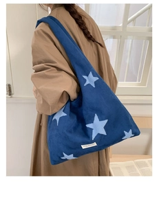 Detail of winter star embroidered plush tote bag showing the soft texture and logo label