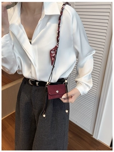 Detail of burgundy micro crossbody bag with silk scarf woven strap and metallic buckle