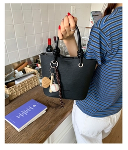 Litchi pattern bucket bag featuring a unique baseball glove and bat charm set