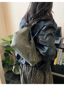Chic olive green shoulder bag with leather fringe detailing shown in a lifestyle setting