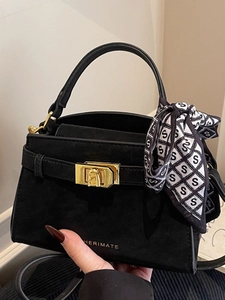 Elegant black suede handbag with gold buckle and decorative black and white silk scarf