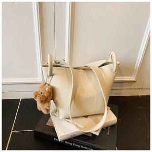Détail du sac seau blanc crème avec texture cuir grainé et charmant pendentif ours en peluche