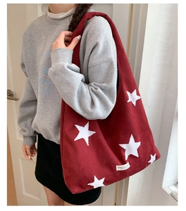 Detail of red plush tote bag showing star embroidery and spacious interior capacity