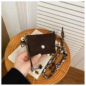 Detail of dark brown suede mini bag featuring wood beads and heart pattern silk scarf
