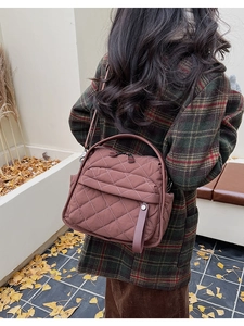 Vista posteriore della modella con borsa tote trapuntata marrone con rombi